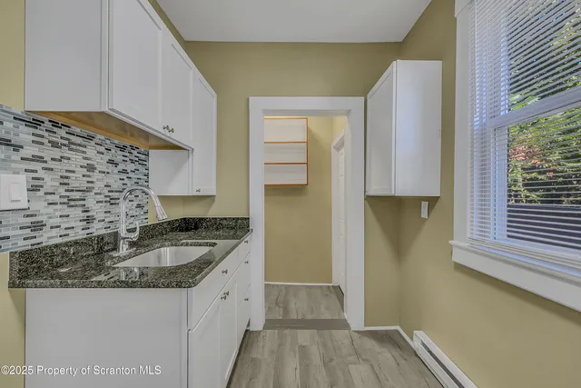a kitchen with granite countertop a sink and a stove top oven
