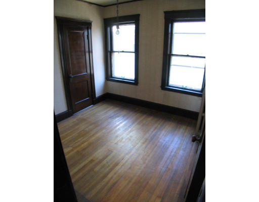 584 Centre Street Boston, MA 02130 - Photo 19 of 26 a view of an empty room with wooden floor and a window