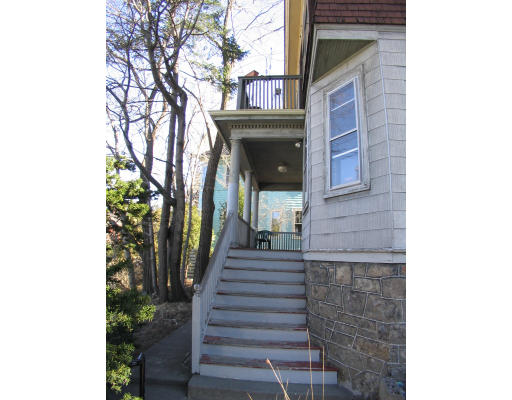 584 Centre Street Boston, MA 02130 - Photo 8 of 26 a view of a brick house with large windows and a small yard
