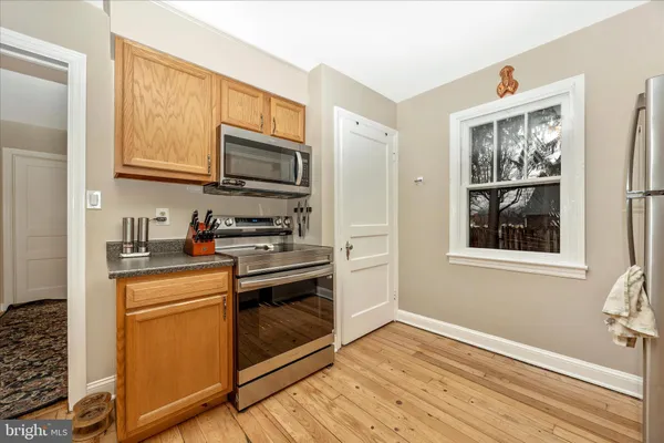 a kitchen with stainless steel appliances granite countertop a stove microwave and cabinets