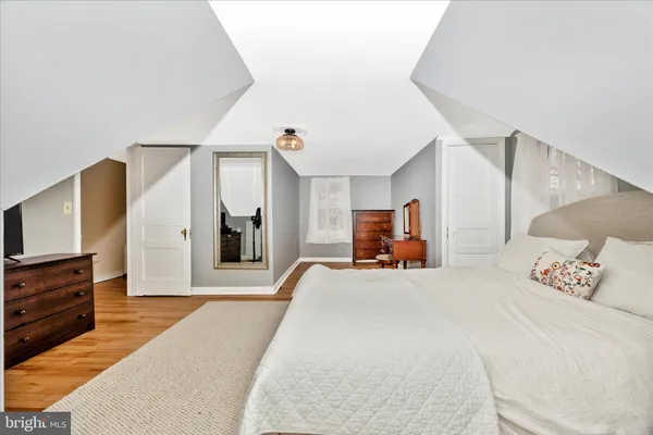 a bedroom with a large bed and a flat tv screen on a dresser