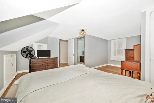 a bedroom with a bed and a chair with the view of kitchen