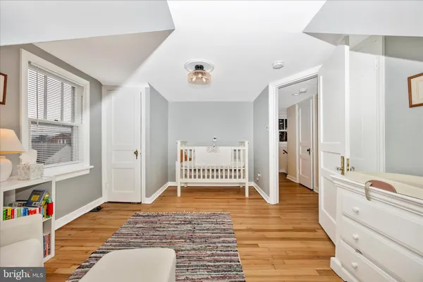 a view of a bedroom with wooden floor and windows