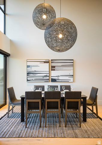 213 Lionsback Loop, Unit 38 Moab, UT 84532 - Photo 10 of 26 Dining area featuring soaring ceilings with statement spherical pendant lighting, light wood-finish flooring, and a sliding glass door