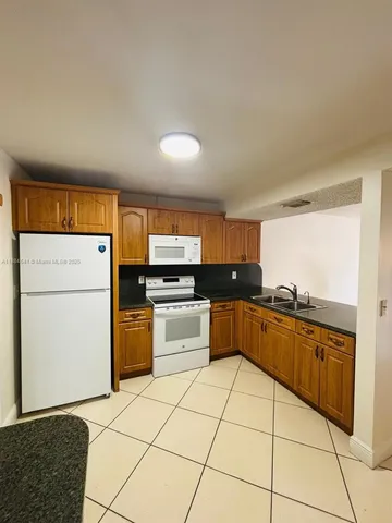 a kitchen with stainless steel appliances a sink a stove a microwave a sink a counter top space and cabinets