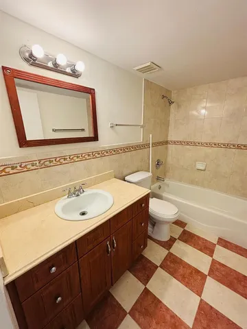 a bathroom with a sink a toilet a mirror and bathtub