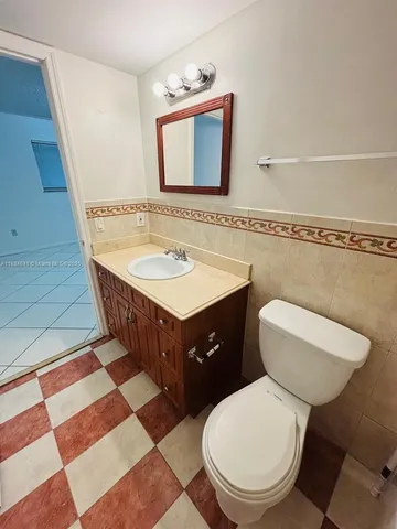 a bathroom with a toilet a sink and mirror