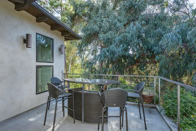 a roof deck with table and chairs and wooden floor