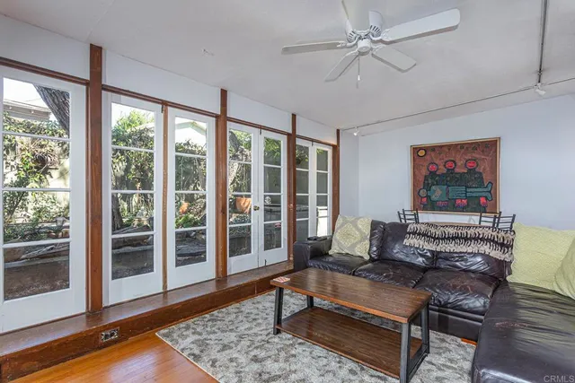 a living room with furniture a flat screen tv and a floor to ceiling window