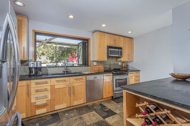 a kitchen with granite countertop a stove sink and cabinets