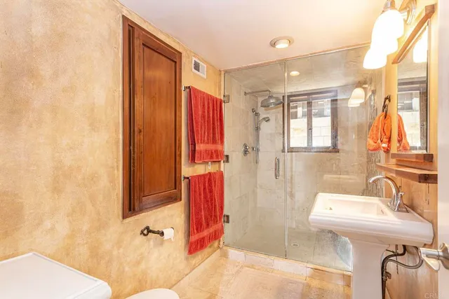 a bathroom with a sink a toilet and shower