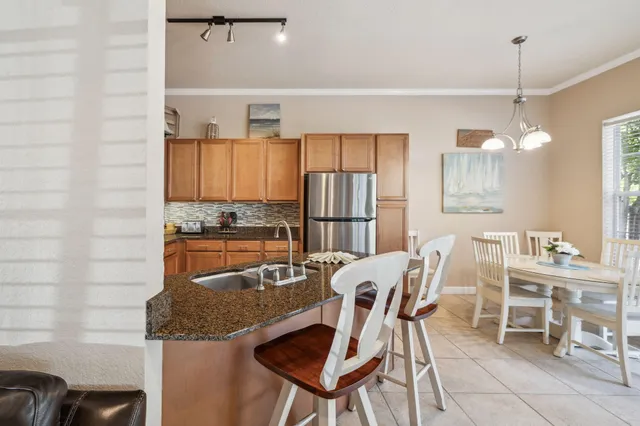 a kitchen with granite countertop kitchen island stainless steel appliances a table and chairs in it