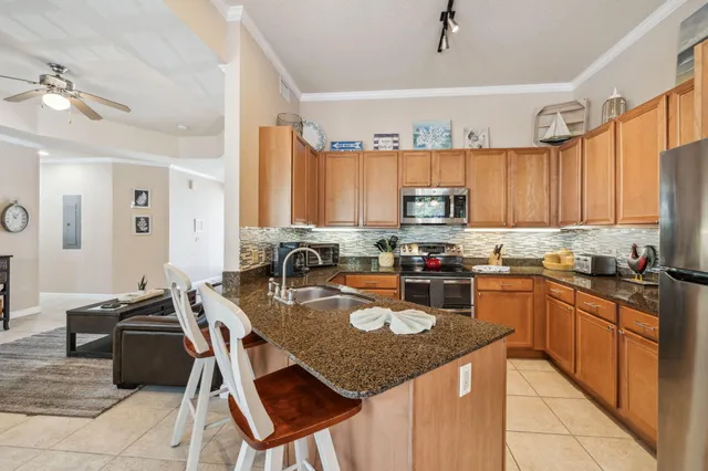 a kitchen with kitchen island granite countertop a sink counter top space appliances and cabinets