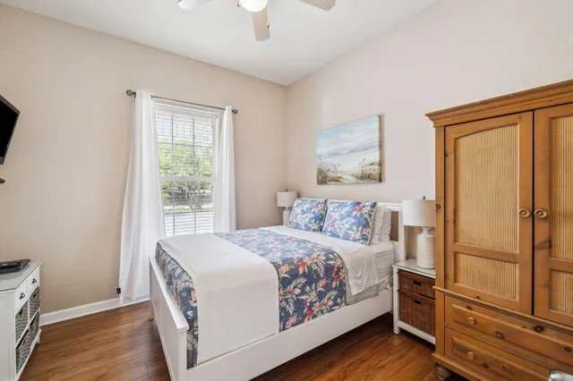 a bedroom with a bed wooden floor and window