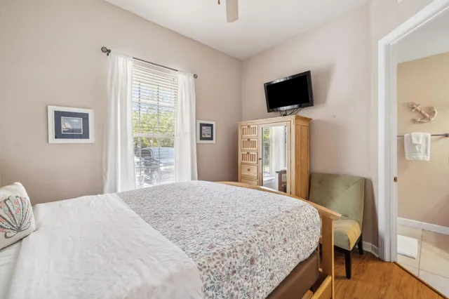 a bedroom with a bed tv and a window