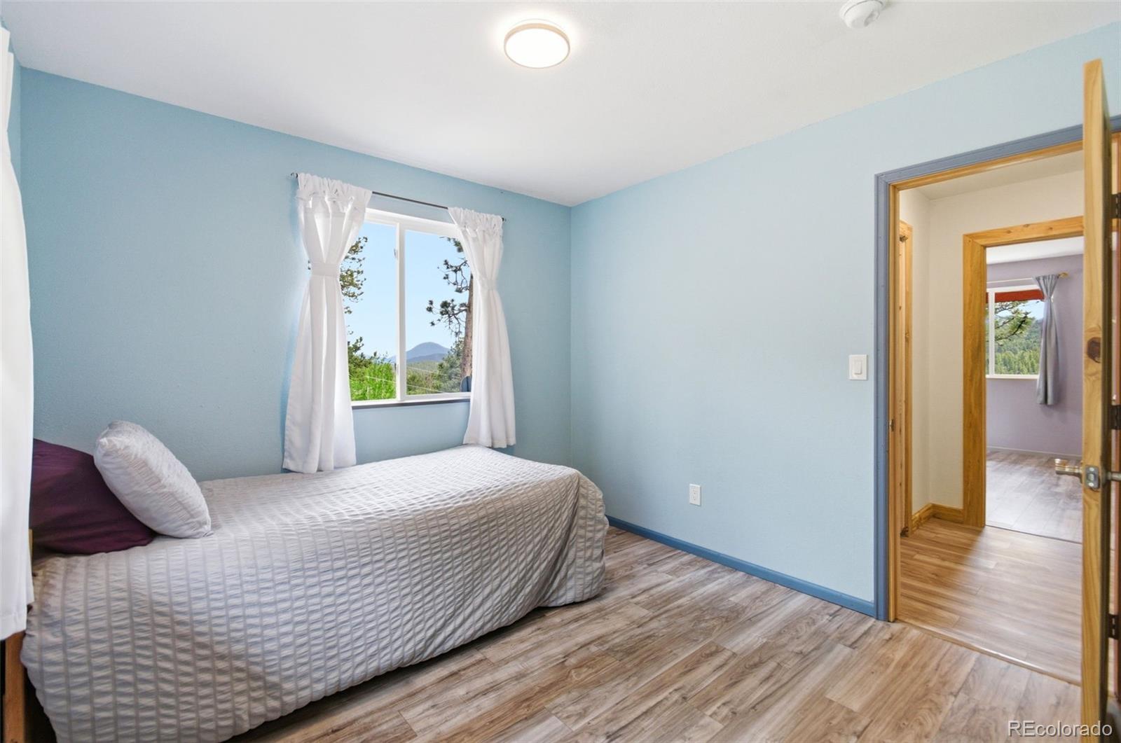 202 Badger Lane Bailey, CO 80421 - Photo 29 of 50 a bedroom with a bed and wooden floor