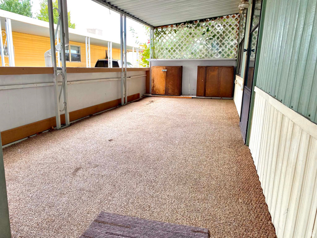 1111 North 2000 West, Unit 147 Ogden, UT 84404 - Photo 3 of 12 Covered patio featuring a textured floor surface, white lattice detailing, and built-in storage units