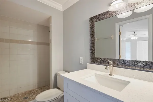 a bathroom with a sink toilet vanity and shower