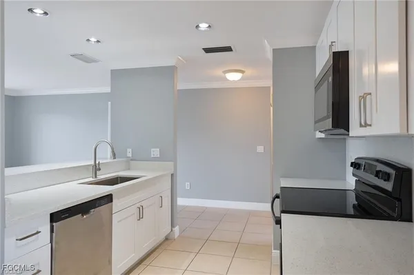 a kitchen with stainless steel appliances granite countertop a sink and a refrigerator