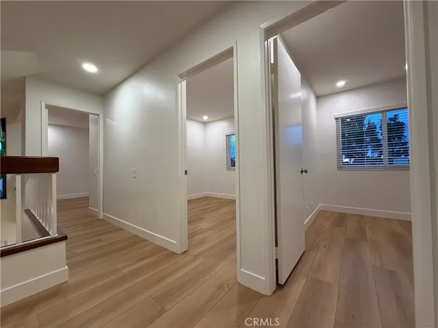 an empty room with wooden floor and window