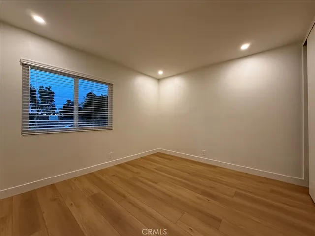 an empty room with wooden floor and painting on the wall
