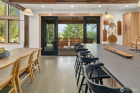 a view of a dining room with furniture large windows and wooden floor