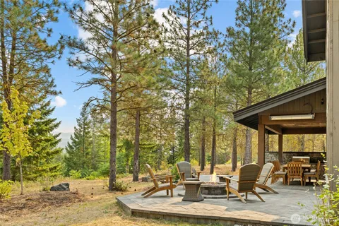 a view of the patio with couches and chairs under an umbrella