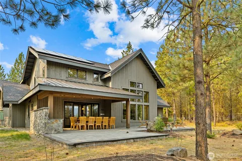 a front view of a house with large trees