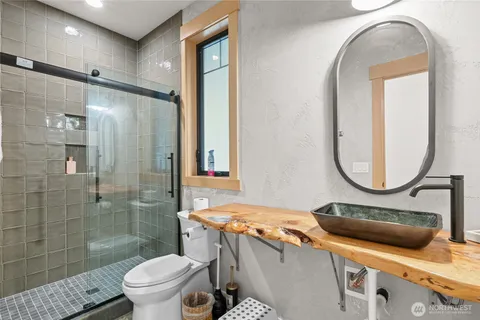 a bathroom with a sink a toilet and a mirror