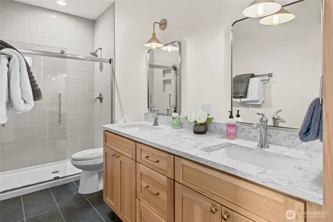 a bathroom with a double vanity sink toilet and shower