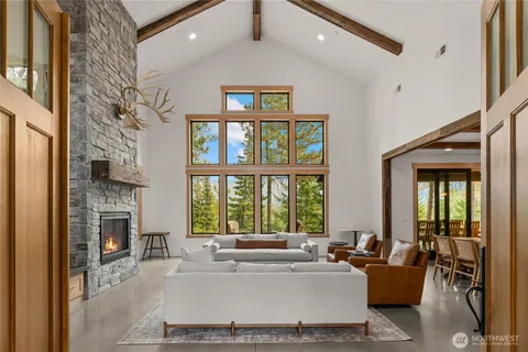 a living room with fireplace furniture and a large window