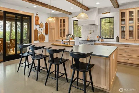 a dining hall with stainless steel appliances granite countertop a table and chairs a refrigerator with wooden floor