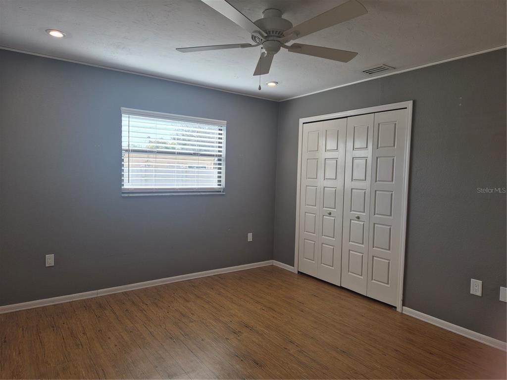 1080 Leeward Road Venice, FL 34293 - Photo 14 of 33 a view of an empty room with wooden floor and a window