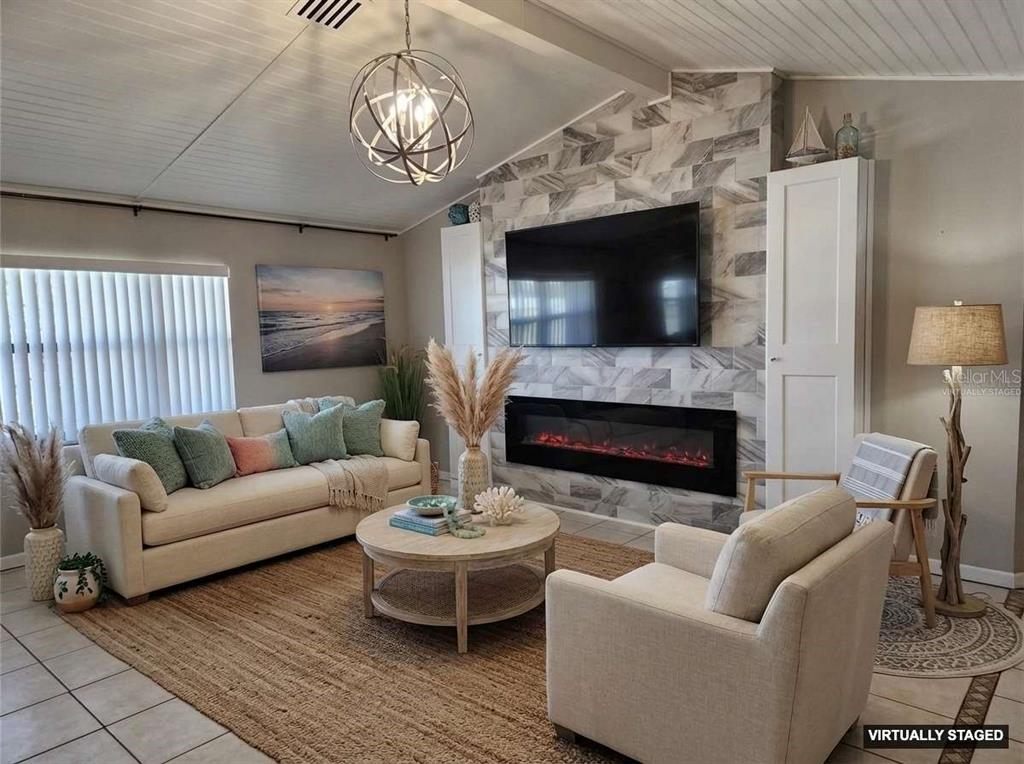 1080 Leeward Road Venice, FL 34293 - Photo 20 of 33 a living room with furniture a flat screen tv and a fireplace