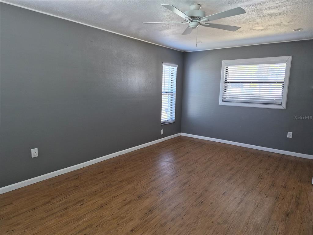 1080 Leeward Road Venice, FL 34293 - Photo 25 of 33 an empty room with wooden floor windows and fan