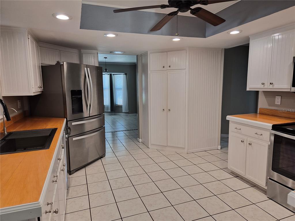 1080 Leeward Road Venice, FL 34293 - Photo 7 of 33 a kitchen with white cabinets a sink a stove and a refrigerator