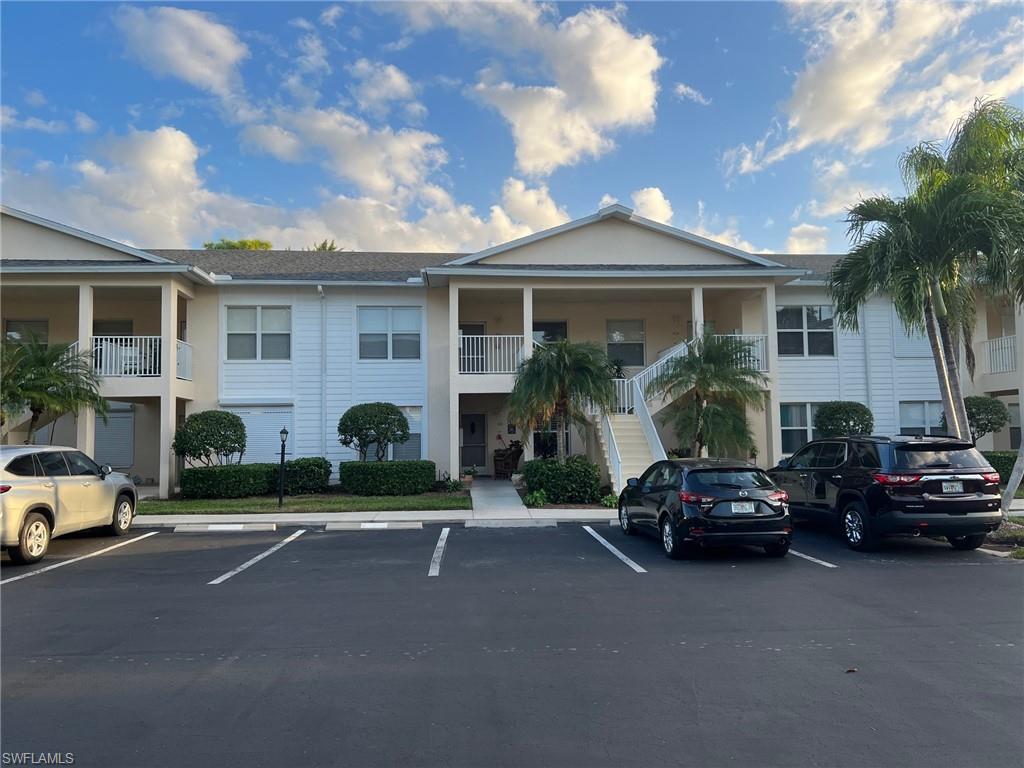 1220 Sarah Jean Circle, Unit L103 Naples, FL 34110 - Photo 1 of 23 a front view of a house with cars parked