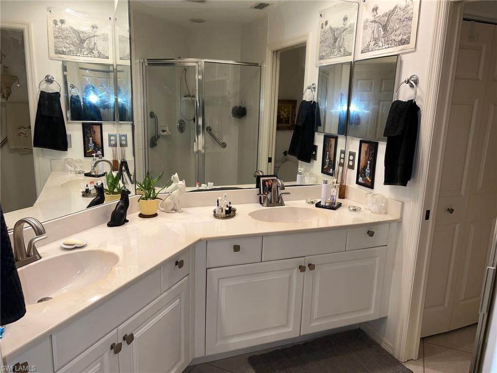 1220 Sarah Jean Circle, Unit L103 Naples, FL 34110 - Photo 11 of 23 a bathroom with a double vanity sink and mirror