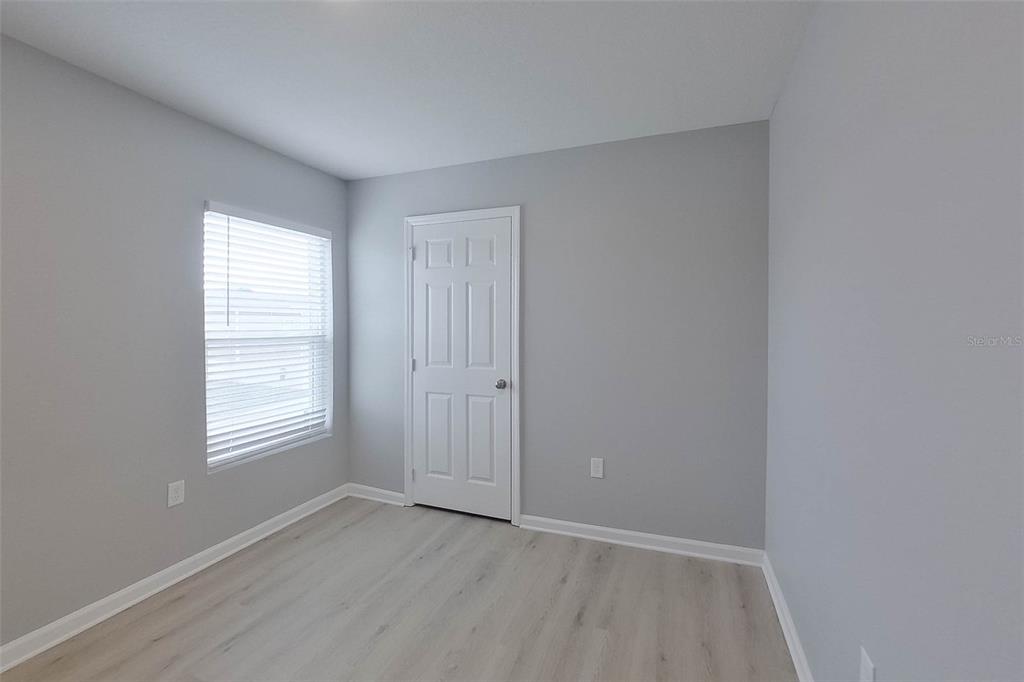 1709 Nebraska Loop Sumterville, FL 33585 - Photo 11 of 22 a view of an empty room with wooden floor and a window