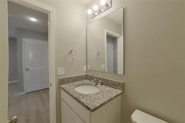 a bathroom with a granite countertop sink and a mirror