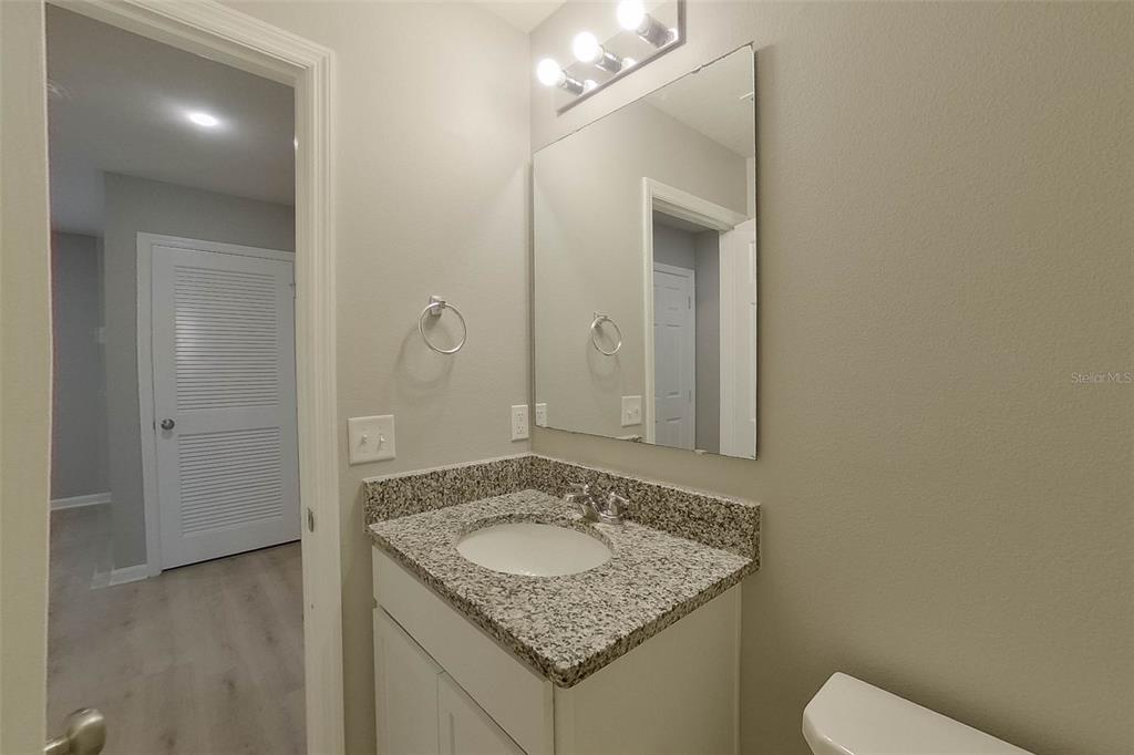 1709 Nebraska Loop Sumterville, FL 33585 - Photo 13 of 22 a bathroom with a granite countertop sink and a mirror