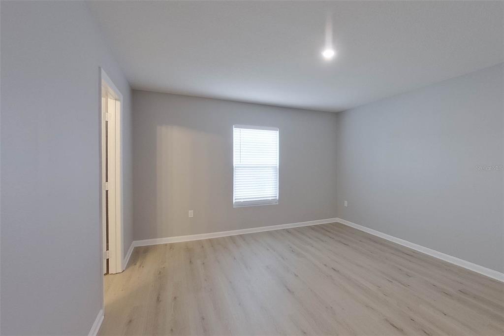 1709 Nebraska Loop Sumterville, FL 33585 - Photo 15 of 22 a view of an empty room with wooden floor and a window