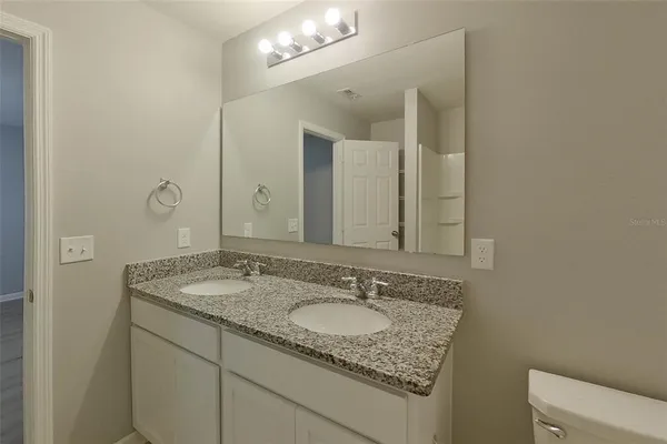 a bathroom with a granite countertop sink and a mirror