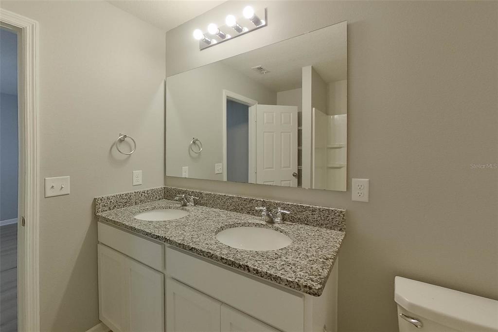 1709 Nebraska Loop Sumterville, FL 33585 - Photo 18 of 22 a bathroom with a granite countertop sink and a mirror