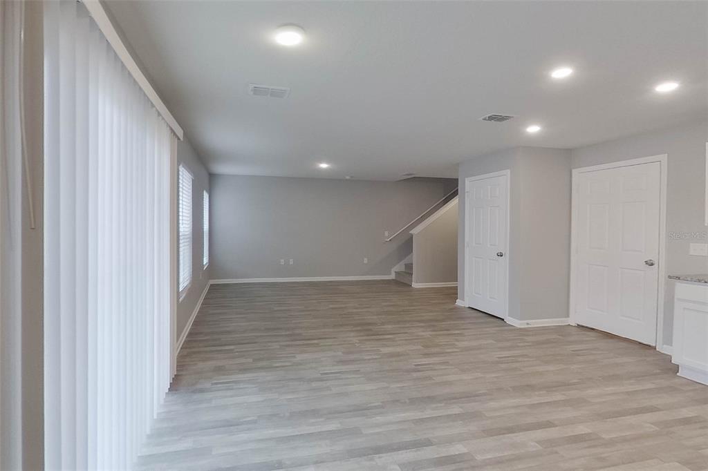 1709 Nebraska Loop Sumterville, FL 33585 - Photo 3 of 22 an empty room with wooden floor and windows