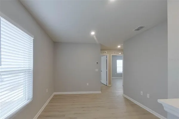a view of hallway with a window and wooden floor