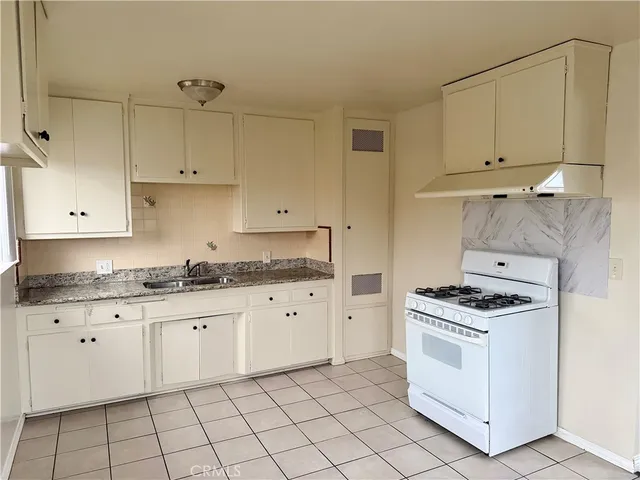a kitchen with granite countertop white cabinets and white appliances