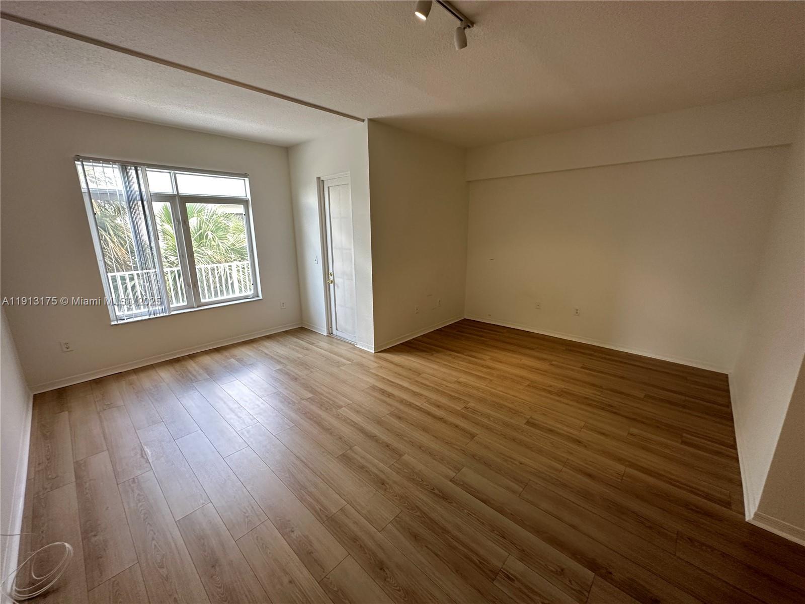 1200 Town Center Drive, Unit 217 Jupiter, FL 33458 - Photo 15 of 37 an empty room with wooden floor and windows