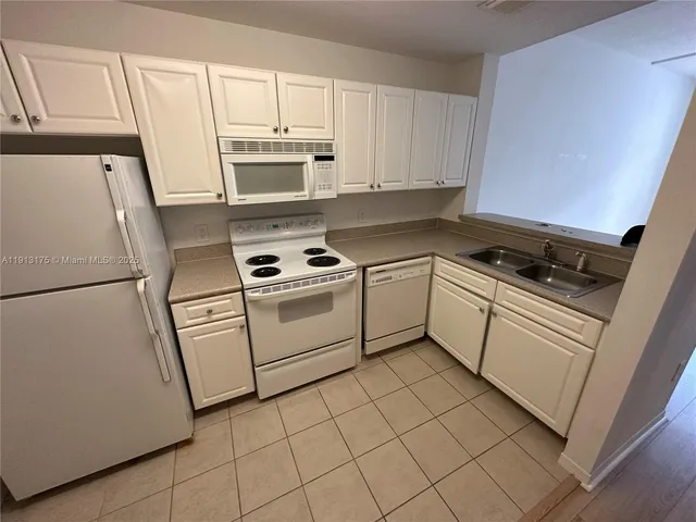 a kitchen with white cabinets and white appliances