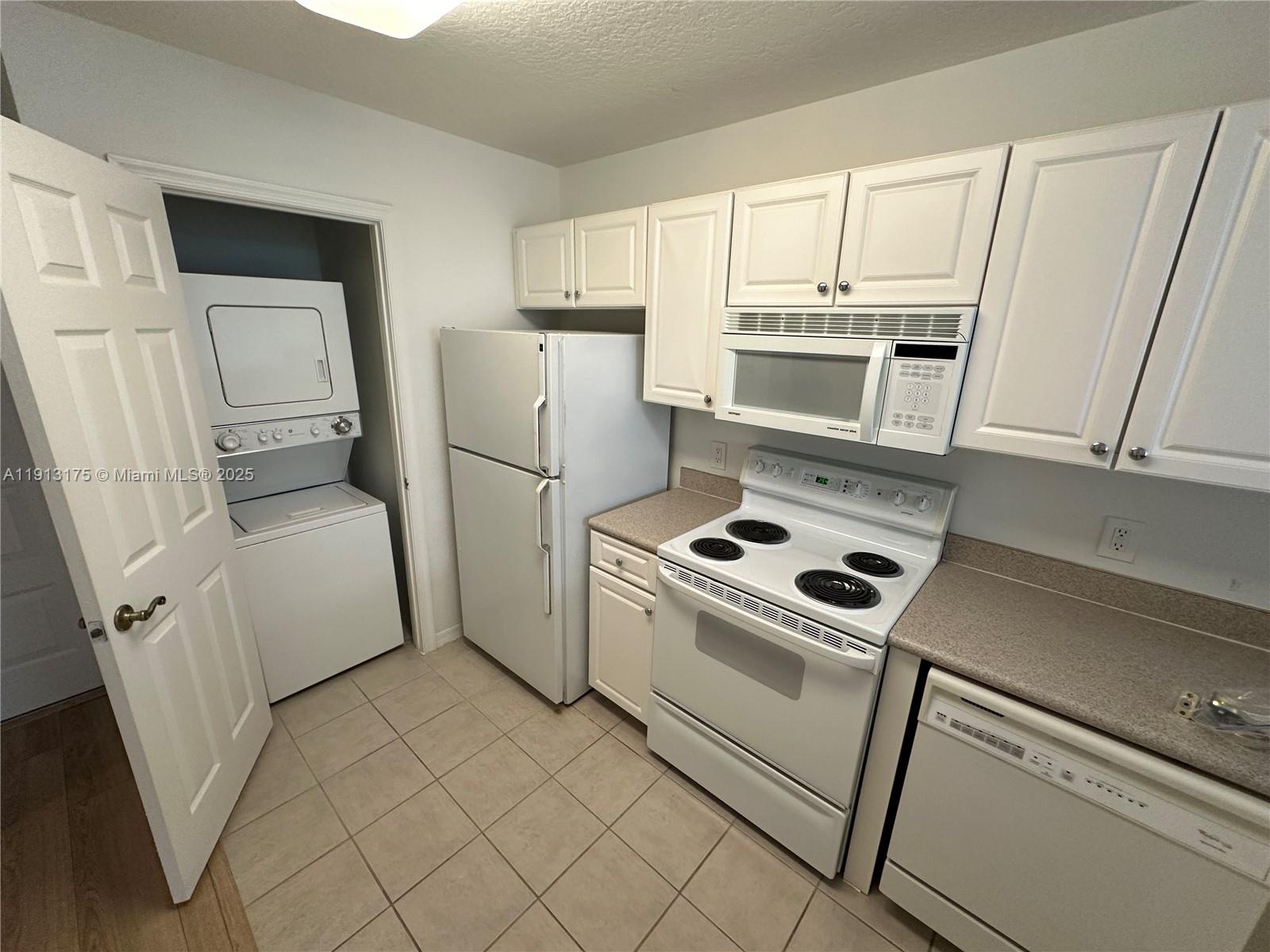 1200 Town Center Drive, Unit 217 Jupiter, FL 33458 - Photo 18 of 37 a kitchen with white cabinets and white appliances
